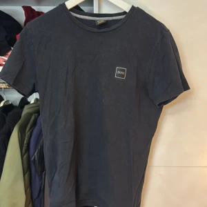 Svart t-shirt från Boss - Snygg svart t-shirt från Boss med en liten logotyp på bröstet. Perfekt för en stilren och avslappnad look. Storlek S men passar även XS