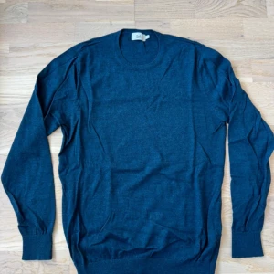 Mörkblå tröja i merinoull från D+LJ - Säljer en stilren mörkblå tröja från D+LJ i 100% merinoull. Tröjan har en klassisk rund halsringning och långa ärmar. Perfekt för kyligare dagar med sin mjuka och värmande kvalitet. Ett måste i garderoben för den som älskar komfort och stil. Sitter lite mindre så S-M. Hör av er vid frågor eller funderingar🤗