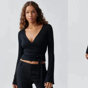 Svart omlottopp - Snygg svart omlottopp med långa ärmar och knytband i midjan. Är helt ny och därför jätte bra skick.