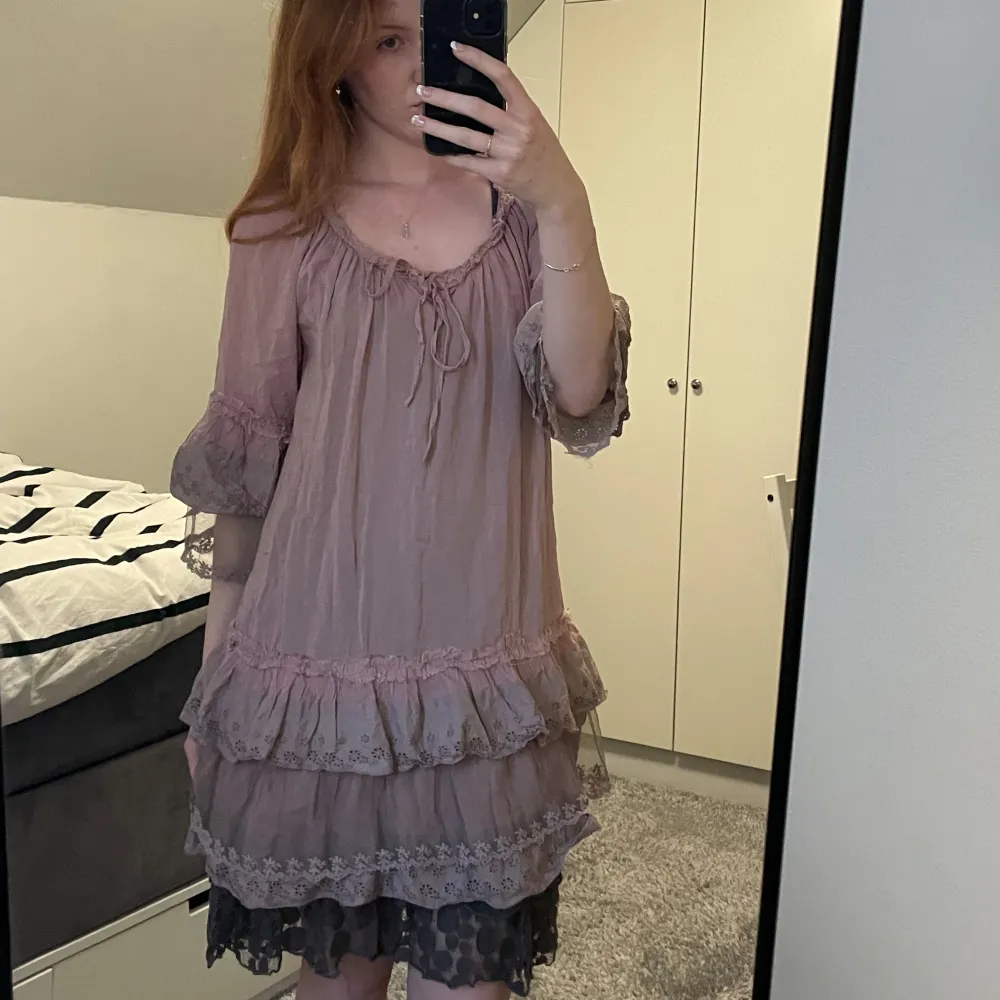 Charmig beige/rosa klänning med volanger och spetsdetaljer. Klänningen passar jättebra att styla med ett skärp eller en korsett. Den har både en inner och en ytterklänning🩷. Mekot.