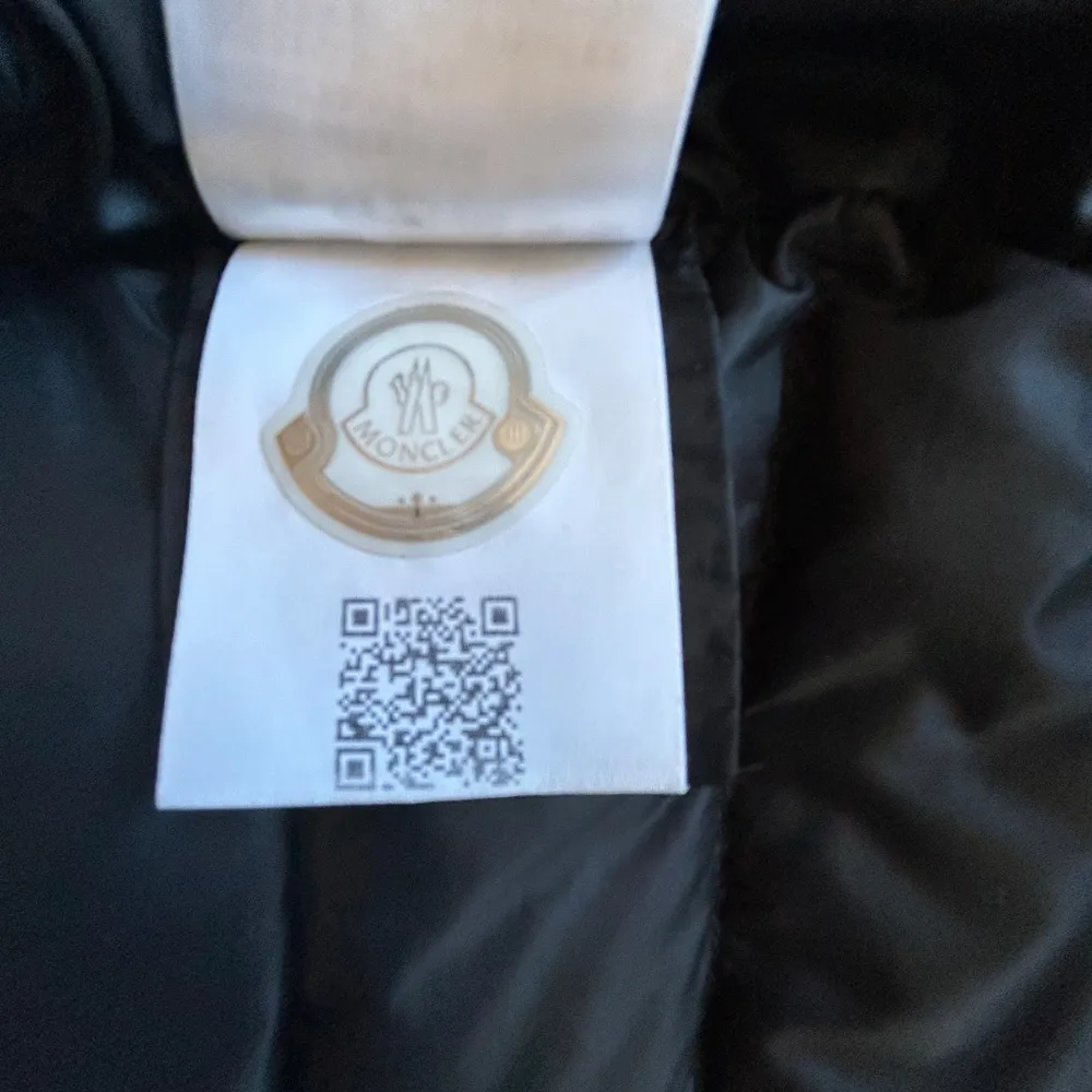 Snygg svart dunväst från Moncler med dragkedja och två fickor med dragkedjor. Perfekt för kyligare dagar och ger en stilren look. Moncler-loggan pryder bröstet för en exklusiv touch.. Takit.