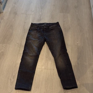 Mörkgrå jeansbyxor - Snygga mörkgrå jeansbyxor med klassisk femficksdesign. De har en normal passform och är perfekta för en avslappnad stil. Byxorna knappar  fram.