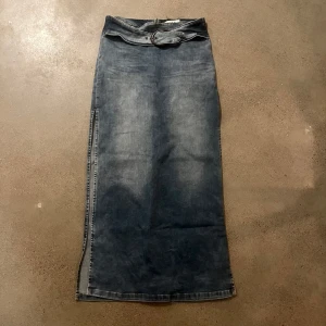 Jeanskjol från BDG - Fin lång jeanskjol från BDG med ett bälte i midjan och dragkedja. Bra kvalité 8/10 och skönt material som inte sitter åt.