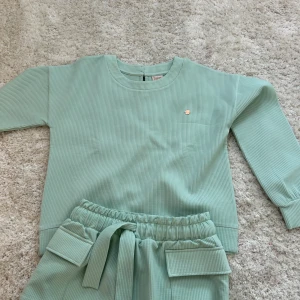 Mintgrön tröja från Ted baker  - Säljer en mintgrön ribbad tröja från Ted Baker. Tröjan har långa ärmar och en liten dekorativ detalj på bröstet. Perfekt för en avslappnad stil. 💚 Man får byxorna med i settet men kan köpa separat 