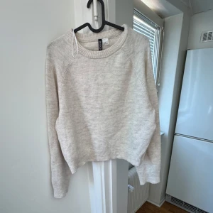 Beige tröja från H&M Divided - Säljer en mysig beige tröja från H&M Divided. Tröjan har en rund halsringning och långa ärmar, perfekt för kyligare dagar. Den är tillverkad i ett mjukt material som känns skönt mot huden. Passar bra till både jeans och kjol.