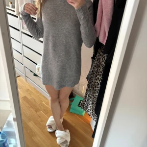 Grå stickad klänning g från Zara - Säljer en mysig grå stickad klänning från Zara. Tröjan har en normal passform med långa ärmar och ribbade detaljer vid hals, ärmslut och nederkant. Perfekt för kyliga dagar och passa så bra ihop med boots! 