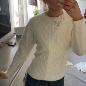 Vit stickad tröja - Säljer en mycket mysig vit stickad tröja med ett klassiskt flätmönster. Tröjan är väldigt skön o sitter jätte fint💕💕perfekt nu till vårnen 🌤️