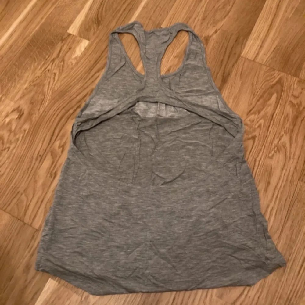 Säljer en grå linnetopp från Better Bodies, med en vit rand och svart logga på framsidan. Toppen har en brottarrygg och är perfekt för en avslappnad stil. Materialet är mjukt och bekvämt.Ny!!. Yläosat.