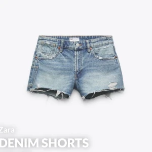 Blå jeansshorts från Zara - Säljer ett par coola blå jeansshorts från Zara med slitna detaljer och fransar. Perfekta för en avslappnad sommarlook. De har en klassisk femficksdesign och knappgylf.