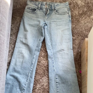 Ljusblå jeans med bootcut - Säljer ett par ljusblå jeans med bootcut-stil. De har en klassisk femficksdesign och är perfekta för en avslappnad look. Jeansen har en knapp- och dragkedjestängning framtill. Har haft på mig dessa några gånger och inga skador alls.