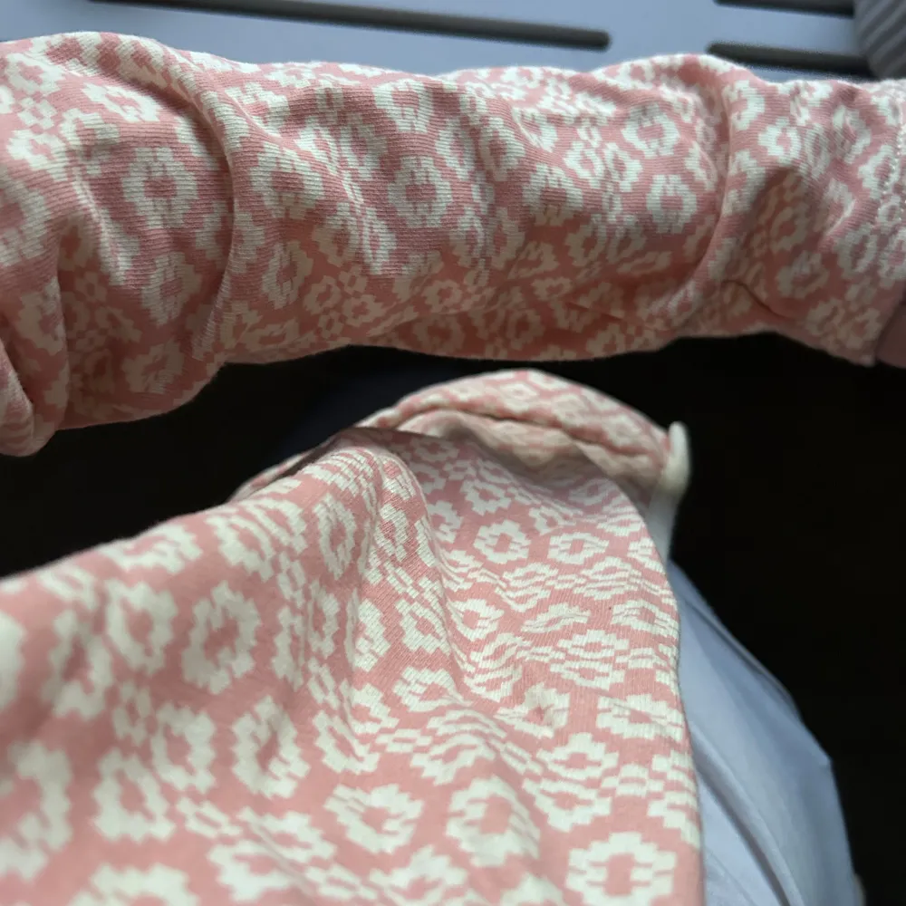 Säljer en söt rosa kofta med vitt mönster. Koftan har en öppen design och långa ärmar, perfekt för att lägga till en färgklick i din garderob. Passar bra till både jeans och kjol. Perfekt för vår och sommar!. Neuletakit & Villapaidat.