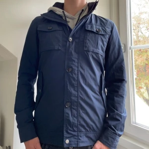 J.Lindberg Jacka - Riktigt fet och eftertraktad J.Lindberg Jacka i storlek S, modellen på bilden är 182 cm. Varan är i så gott som nyskick och kommer helt utan defekter. Nypris: 4000 kr, mitt pris: 1999 kr. Priset kan dock diskuteras! Hör gärna av er vid frågor😁