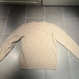 Beige stickad tröja - Säljer en stilren beige stickad tröja från John Henric. Nypris 1100