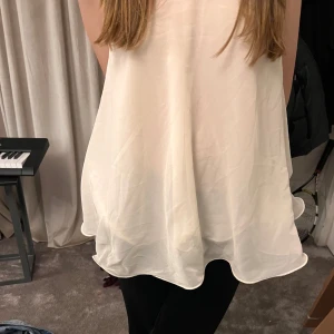 Vit ärmlös blus - Säljer en luftig och stilren vit blus med ärmlös design. Perfekt för varma dagar eller sommarens fester. Den har en lätt och flödande passform som ger en elegant look. Passar bra med både sneakers och klackar.❤️