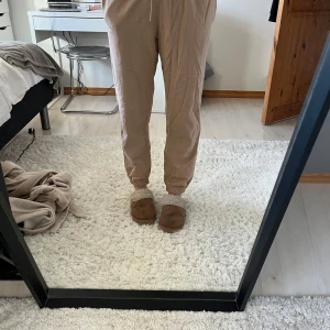 Beige mjukisbyxor från Nike - Säljer ett par beige mjukisbyxor från Nike. Byxorna har en avslappnad passform med resår i midjan och vid bensluten samt snörning i midjan. Nike-logga på sidan av ena benet. Endast använda fåtal (2-3) gånger.💜stl S men ganska små i storleken
