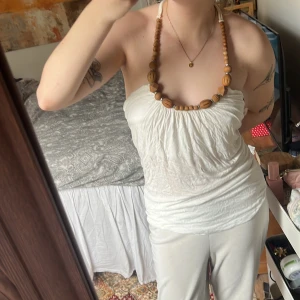 Vit axelbandslös topp - Säljer en vit axelbandslös topp med rynkad design. Toppen har en enkel och stilren look, perfekt för varma dagar. Den är lätt och luftig, vilket gör den bekväm att bära.Det står st Xs men jag tycker den passar mig bra som har S den är tät stretchig i materialet! Jättefin verkligen till sommaren🌺🫶🏼