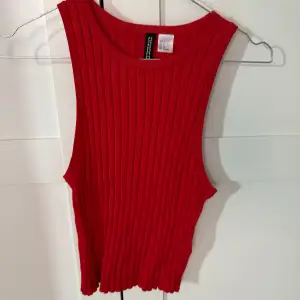 Säljer en snygg röd ribbad linnetopp från Divided. Perfekt för varma dagar eller som ett lager under en jacka. Toppen har en enkel och stilren design.