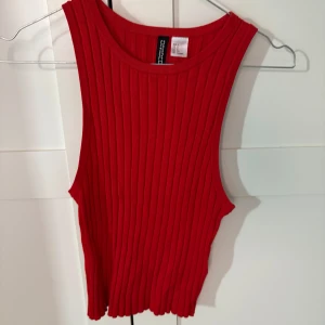 Röd ribbad linnetopp från Hm - Säljer en snygg röd ribbad linnetopp från Divided. Perfekt för varma dagar eller som ett lager under en jacka. Toppen har en enkel och stilren design.
