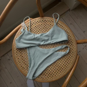 Ljusgrön bikini från SHEIN - Snygg ljusgrön bikini från SHEIN med enkel design. Toppen har smala axelband och byxan har en klassisk skärning. Perfekt för en dag på stranden eller vid poolen. Är lite sönder på sidan men inget man ser eller tänker på 