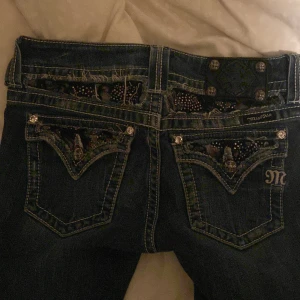 Miss me jeans  - Såå snygga miss me jeans med detaljer och knappar på bakfickorna. Jeansen har en bootcut-stil och låg midja. En knapp är borta där fram men inget som märks. Står storlek 28 i byxan. Innerbenslängden är 81cm. Skriv för fler frågor💗