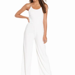Vit jumpsuit från NLY Trend - Snygg vit jumpsuit med smala axelband och vida ben. Perfekt för en stilren look. Tillverkad i mjukt och stretchigt material för extra komfort. Perfekt till studentveckan❤️