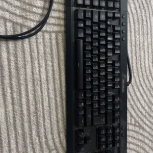 Corsair mekaniskt tangentbord med RGB-belysning - Säljer ett Corsair mekaniskt tangentbord med RGB-belysning. Tangentbordet har en robust design med svarta tangenter och en sladdanslutning. Perfekt för gaming och arbete med anpassningsbar belysning i flera färger.