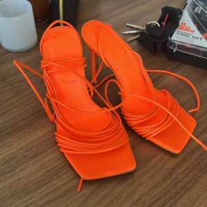 Orange klackskor med snörning - Snygga orange klackskor med smala remmar och snörning från Asos. Använda endast 1 gång så i bra skick. 