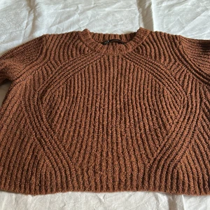 Brun stickad tröja från ONLY - Säljer en brun stickad tröja från ONLY med grov ribbad struktur och rund hals. Tröjan har långärmade ärmar och ett snyggt mönster som ger en cool och modern vibe. Perfekt för dig som gillar mysiga och trendiga plagg med lite extra textur.