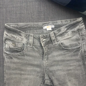 Grå jeans med broderade bakfickor Gina Tricot - Snygga grå jeans från Gina Tricot i storlek 152. Modellen har klassisk femficksdesign och coola broderade detaljer på bakfickorna med knappar. Jeansen har en rak passform och är tillverkade i mjukt jeanstyg med slitningar för en trendig look. Dem är bootcut o lowiast.😊