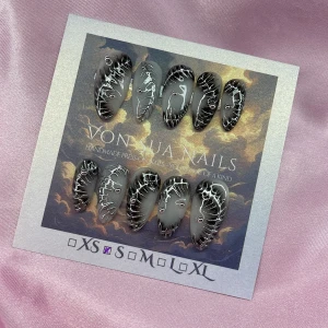Z1NK (S);Medium Almond - Handgjorda press-on naglar i svart och vitt med coola handmålade 3D silvermönster och små rhinestones. Naglarna har en mandelformad design och kommer i S: 15 mm, 11,5 mm, 12 mm, 11 mm, 9 mm. Perfekt för dig som vill ha en edgy och unik look.
