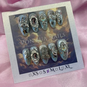 BlueJK (M);Medium Almond - Säljer ett set med handgjorda press-on naglar i storlek M: 16 mm, 12 mm, 12,5 mm, 11,5 mm, 10 mm. Naglarna har en skimrande blå/vit fade bas och är dekorerade med 3D-silverdetaljer som fjärilar, stjärnor, motiv och en ramar med BTS medlemmen JK. Designen är riktigt unik med coola cateye accenter.