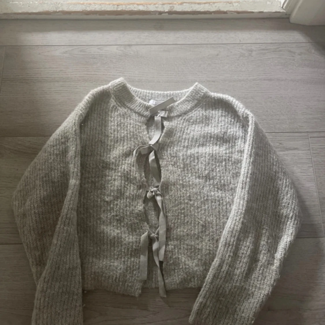 Stickad tröja med rosetter 