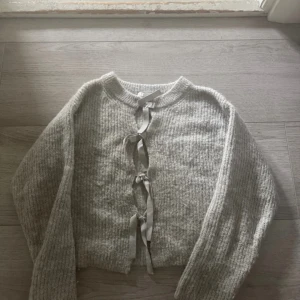 Stickad tröja med rosetter  - Supermysog tröja med rosetter 