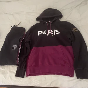 Paris Saint-Germain hoodie - Säljer en snygg hoodie x byxor från Jordan x Paris Saint-Germain i svart och vinrött. Materialet är mjuk bomull och polyester, perfekt för chill eller sport. 
