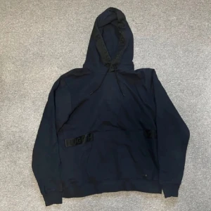 Mörkblå hoodie från Hugo i bomull - Svart hoodie från Hugo i storlek M. Tröjan har en klassisk huva med snörning och ribbade muddar vid ärmslut och nederkant. Materialet är mjuk bomull och det finns en diskret Hugo-logga på magen. Perfekt för chill dagar och streetwear-stil.