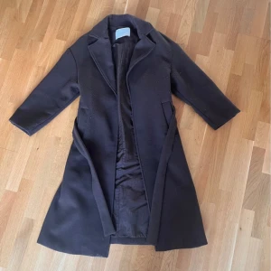 kappa - lite tjockare mörkbrun kappa från Bershka i använt skick, hela kappan är nopprig och har även ett hål under ena armen (dock i sömmen så lätt att laga). Den ser fortfarande väldigt fin ut på. Slits i båda sidorna