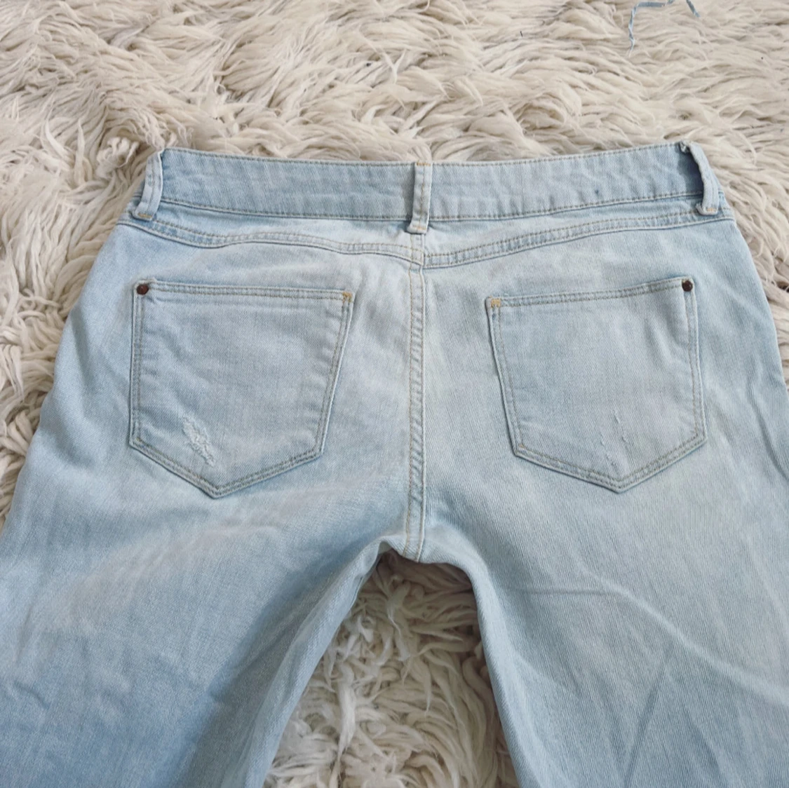 Lågmidjade ljusblåa bootcut jeans med slitningar  - 1