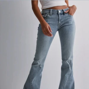 Bootcut jeans från True Religion - Snygga ljusblå bootcut jeans från True Religion med klassiska fickor och dekorativa sömmar bak. Jeansen har låg midja och är tillverkade i mjukt denim med dragkedja och knapp framtill. Perfekta för dig som gillar retrovibbar och coola detaljer.