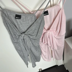 Grå och rosa knyt tröja från Gina Tricot - Två snygga tröjor från Gina Tricot, en i ljusgrått och en i ljusrosa. har ett litet hål men syns knappast 