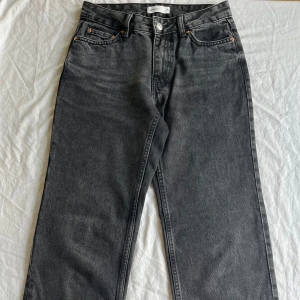 Svarta low straight jeans Gina Tricot - Säljer ett par svarta jeans från Gina Tricot, modellen Perfect Jeans low straight petite. De har en rak passform, klassisk femficksdesign och dragkedja i gylfen. Jeansen är tillverkade i bomull. Längden är av petit serien så innerbenslängden ca 76cm. Storlek 32 och ca 62 cm i midjan. Är i nyskick och endast använa fåtal gången och hela utan något slitage samt rena. (nypris 500kr) Pris kan diskuteras