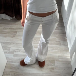 Vita bootcut byxor med fickor - Snygga vita bootcut byxor med låg midja. Köpta för länge sen å har ett fåtal missfärgningar. Annars är de e i bra sick.