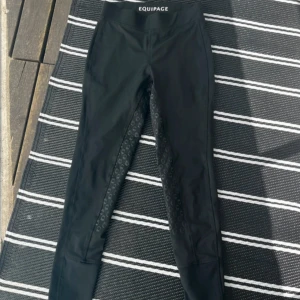 Svarta ridtights  - Svarta ridtights från equipage i skönt & stretchigt material. Helskodda och bra grepp i sadeln. Använda mycket men ändå i bra skick förutom lapparna på insidan som är lite blekta. 