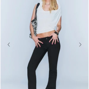 Svarta bootcut jeans Cheeky Monkey - RESARVERADE - Svarta jeans från Cheeky Monkey med bootcut-snitt och låg midja.  Materialet är stretchigt jeans, vilket gör dem sköna och följsamma. Den rosa detaljen är borttagen. Bara att be om egna bilder. Pris går att diskutera. Storlek 25/32