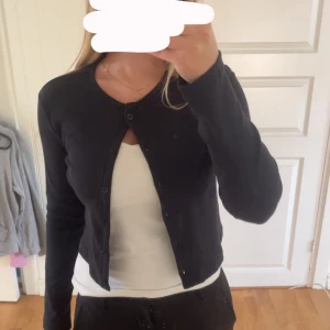 Svart kofta från 157, storlek S - Svart, enkel och stilren kofta från 157 i storlek S. Modellen är croppad med långa ärmar och knappar hela vägen framtill. Perfekt till lager-på-lager och funkar året runt. Mjuk och skön bomullskänsla.