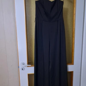 Svart jumpsuit - Elegant svart jumpsuit! Axelbandslös, och oanvänd