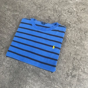 Blå randig tröja från Polo Ralph Lauren - Säljer en blå långärmad tröja från Polo Ralph Lauren med svarta ränder. Hör av dig vid frågor, priset kan diskuteras.  🧵 Skick: Mycket bra 📏 Storlek: XL barn (XS vuxen) 🎨 Färg: Blå med svarta ränder 🏷️ Märke: Polo Ralph Lauren