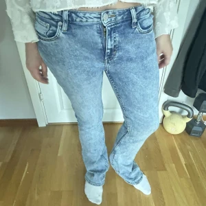 bootcut jeans blå - Säljer ett par snygga acid wash jeans i ljusblått med bootcut passform. Jeansen är mid-waist. 