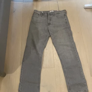 Grå loose fit jeans Jack & Jones storlek 30 32 - Säljer ett par gråa jeans från Jack & Jones i modellen Loose/Chris. Jeansen har loose fit, raka ben och klassisk femficksdesign. Tillverkade i bomull med en snygg, ljusgrå tvätt. Perfekta för dig som gillar avslappnad stil. Storlek 30 32