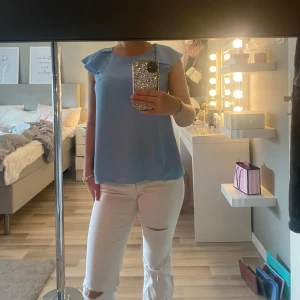 Ljusblå blus med volangärm STOCKH LM - Supersöt ljusblå blus från STOCKH LM i storlek 38 men passar mig som har 35-36. Blusen har volangärmar och en lös passform  ger en chill och luftig vibe. Knäppning bak i nacken för extra detalj.