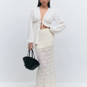 Vit lång kjol i bomull från Gina Tricot - Säljer min jättefina långkok från Gina tricot eftersom att den är för liten. Inte använd då den varit för liten. Är i mjuk, ekologisk bomull. Kjolen är vit och har ett stickat, hålmönstrat diamantmönster som ger en chill och trendig vibe. Perfekt för varma dagar och enkel att styla med crop tops eller skjortor. Kostar 500 kr ordinariepris på ginas hemsida!